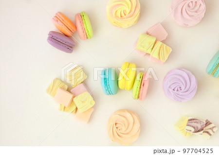 Various of sweets: macaroons, marshmallows and zephyrs. Delicate colored desserts for the holiday. Top view. Copy space. Various of sweets: macaroons, marshmallows and zephyrs. Delicate colored desserts for the holiday. Top view. Copy space. 97704525