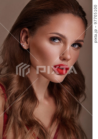 Beautiful sexy woman in a Hollywood manner with curls, natural makeup and red lips.. Beauty face and hair. 97705100