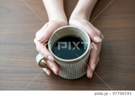 コーヒーの入ったマグカップを持つ女性の手元【パーツカット】 コーヒーの入ったマグカップを持つ女性の手元【パーツカット】 97706593