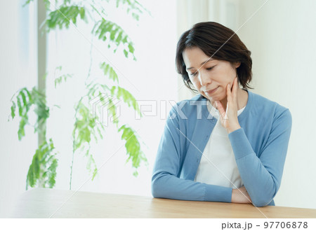 リビングで考え事をするミドル女性 97706878