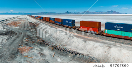 Cargo train passing by the desert Nevada, USA near Salt Flats. A railroad car is a vehicle used for the carrying of cargo on a railway. 97707360