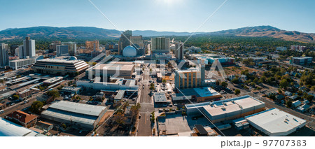 Panoramic aerial view of the city of Reno cityscape in Nevada. Downtown Reno, Nevada, with hotels, casinos and the surrounding High Eastern Sierra foothills. 97707383