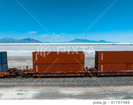 Cargo train passing by the desert Nevada, USA near Salt Flats. A railroad car is a vehicle used for the carrying of cargo on a railway. Cargo train passing by the desert Nevada, USA near Salt Flats. A railroad car is a vehicle used for the carrying of cargo on a railway. 97707489