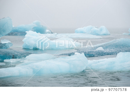 Iceland Lake with Melting Glaciers in Foggy Weather, Pure Blue Ice in Jokulsarlon lagoon. 97707578