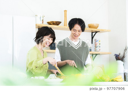 料理をする若い夫婦 97707906