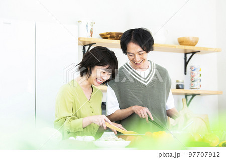 料理をする若い夫婦 97707912