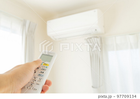 エアコンのスイッチを入れる手元 97709134