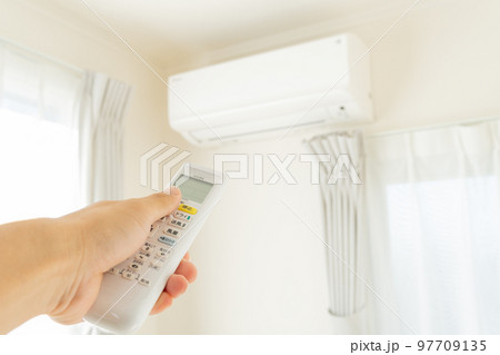 エアコンのスイッチを入れる手元 97709135