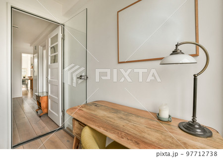 Minimalist interior of study room with parquet floor and white walls furnished with settee and table with shelf rack 97712738