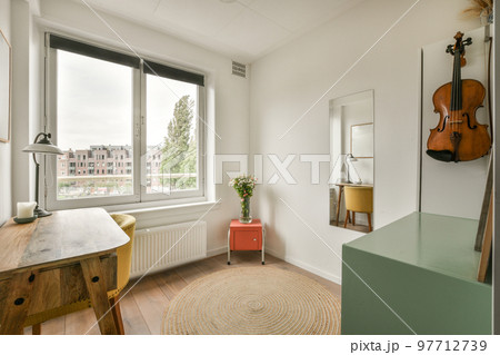 Minimalist interior of study room with parquet floor and white walls furnished with settee and table with shelf rack 97712739