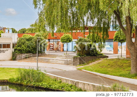 Panorama view of brick houses from an empty sidewalk street with cars, trees and lanterns 97712773