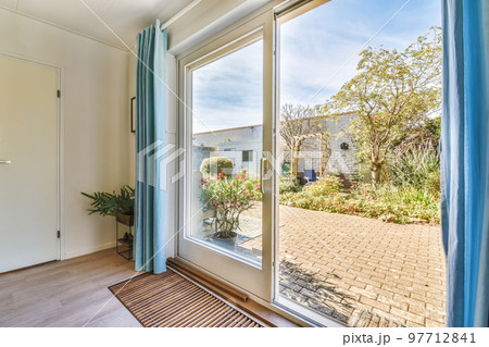 an outside view from the inside of a room with sliding glass doors and blue drapes hanging on the wall an outside view from the inside of a room with sliding glass doors and blue drapes hanging on the wall 97712841