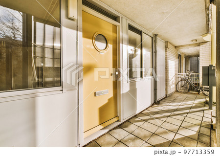 Corridor of contemporary apartment with black closets and opened doorway leading to terrace Corridor of contemporary apartment with black closets and opened doorway leading to terrace 97713359