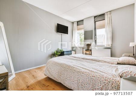 Home interior design of bedroom with bed and wooden wardrobe placed in corner near window in modern apartment Home interior design of bedroom with bed and wooden wardrobe placed in corner near window in modern apartment 97713507