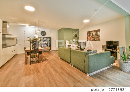 Studio apartment with white walls and open plan kitchen and dining zone with sofa in living room Studio apartment with white walls and open plan kitchen and dining zone with sofa in living room 97713924