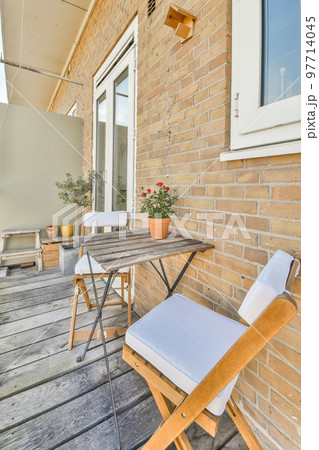 Front view of buildings and cars with bicycles from small balcony with railings 97714045