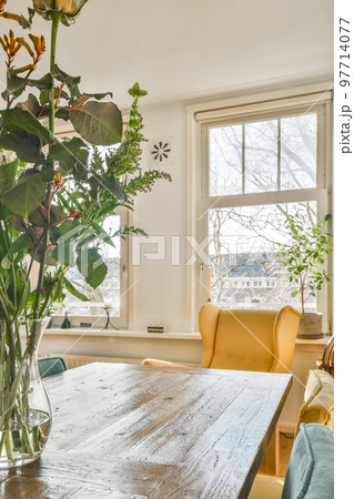 Couches and table located near TV against dining area of spacious room in contemporary apartment 97714077