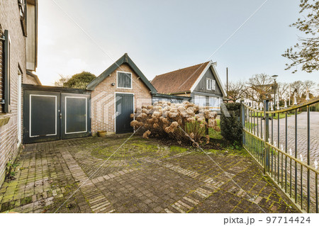 Neat patio with sNeat paved patio with sitting area and small garden near wooden fenceitting area 97714424