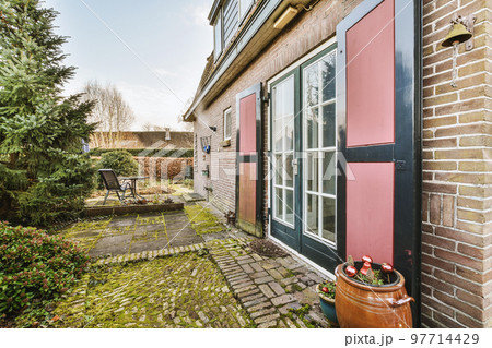 Neat patio with sNeat paved patio with sitting area and small garden near wooden fenceitting area 97714429
