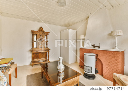 a living room with a fireplace in the center and an old clock on the wall next to the coffee table 97714714
