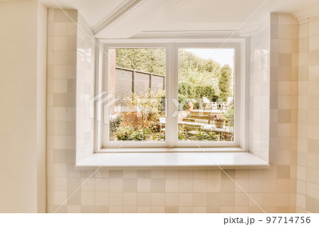 a bathroom window with the view out to the garden from it's bathtub in front of the house 97714756