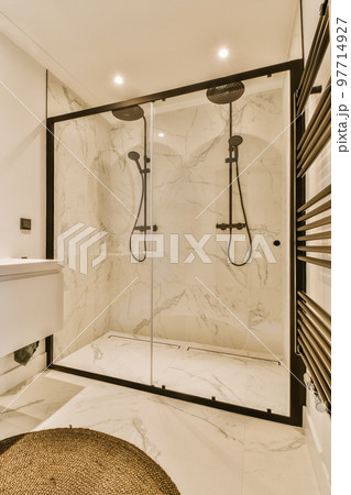 a modern bathroom with marble flooring and black trim on the shower door, along with a round rug in front a modern bathroom with marble flooring and black trim on the shower door, along with a round rug in front 97714927