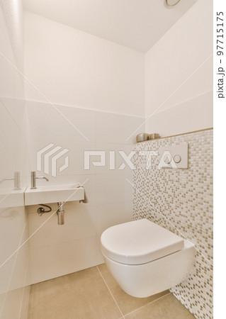 a bathroom with white tiles on the wall and toilet in the corner, there is a sink next to it a bathroom with white tiles on the wall and toilet in the corner, there is a sink next to it 97715175