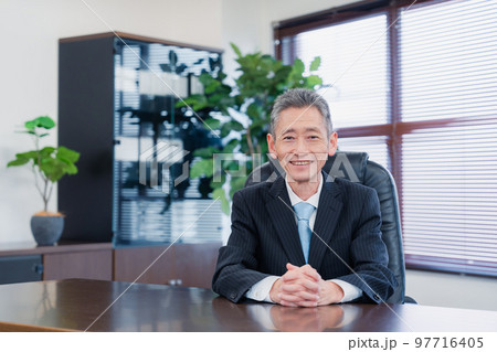 笑顔で椅子に座る経営者の男性 笑顔で椅子に座る経営者の男性 97716405
