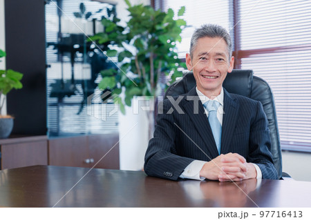 笑顔で椅子に座る経営者の男性 笑顔で椅子に座る経営者の男性 97716413