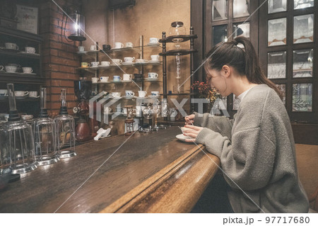 喫茶店で一息つく女性 97717680