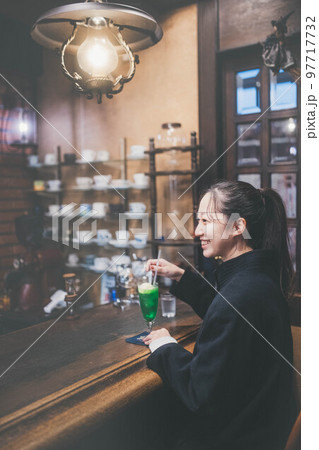 仕事の途中に喫茶店で一息つく女性 仕事の途中に喫茶店で一息つく女性 97717732