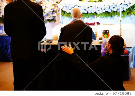 高齢者に手を添えるセレモニーレディー 97719095