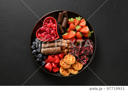 Charcuterie Valentines Day charcuterie board with chocolate sweets. 97719931