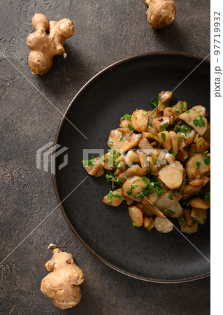 Roasted Jerusalem artichoke root, sunchokes on dark brown. Roasted Jerusalem artichoke root, sunchokes on dark brown. 97719932