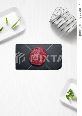 Beef burguer on a kitchen with some herbs 97720017