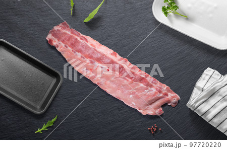 Whole piece of pork ribs on a flat lay of a butcher shop with various items 97720220