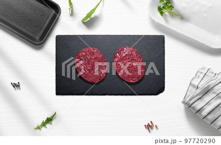 Beef hamburguers on a flat lay of a kitchen with various items 97720290