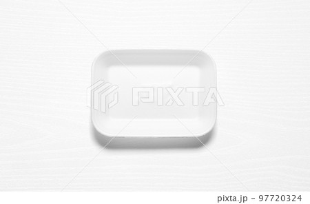 White styrofoam tray against a white wood board 97720324