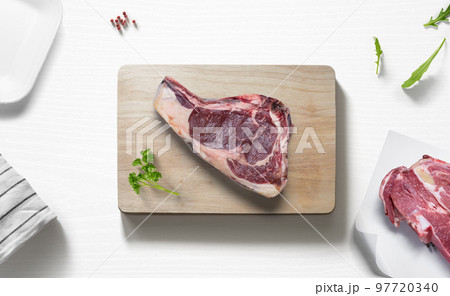 Beef steak over a cutting board with various food items 97720340
