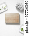 Flat lay of a kitchen with a cutting board and herbs 97720360