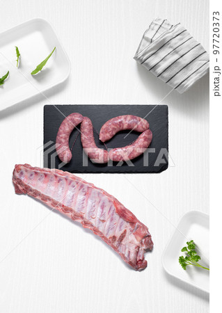 Criollo chorizo and pork ribs on a kitchen with some herbs 97720373