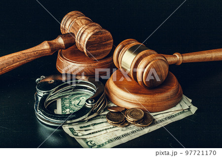 Bribe concept. Dollar banknotes, handcuffs and gavel on dark black table 97721170