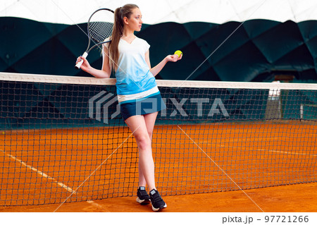 Young woman playing tennis at indoor tennis court 97721266