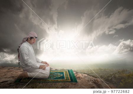 Muslim man with keffiyeh and agal in praying position (salat) on the prayer rug 97722682