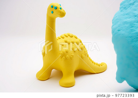 Cute yellow plasticine dragon with green pimples isolated on white background 97723393