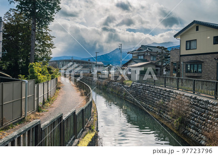 ドラマチックな空と街中を流れる拾ヶ堰【安曇野市堀金】 97723796