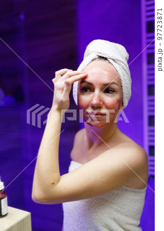 A girl takes care of her face and skin after a shower. A girl takes care of her face and skin after a shower. 97723871