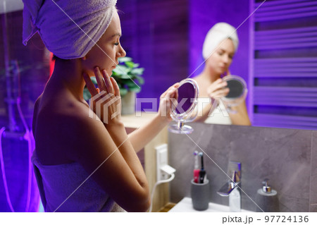 A girl takes care of her face and skin after a shower. 97724136