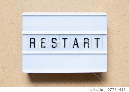 Lightbox with word restart on wood background 97724415