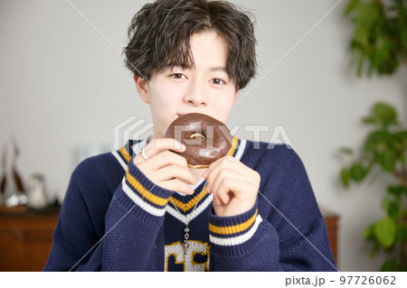 ドーナッツを食べる若い男性 97726062